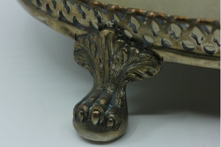  Tinteiro em prata com gradinha com dois depósitos, suportes para canetas, campainha e assente em quatro pés com garras.